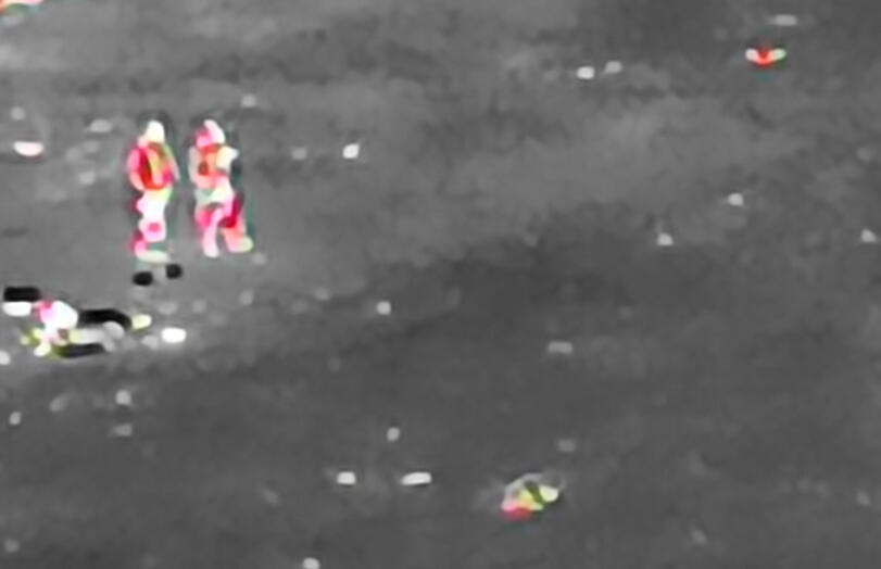 350m, moonless night. Thermal image showing two people clearly visible against a dark moorland landscape at night.